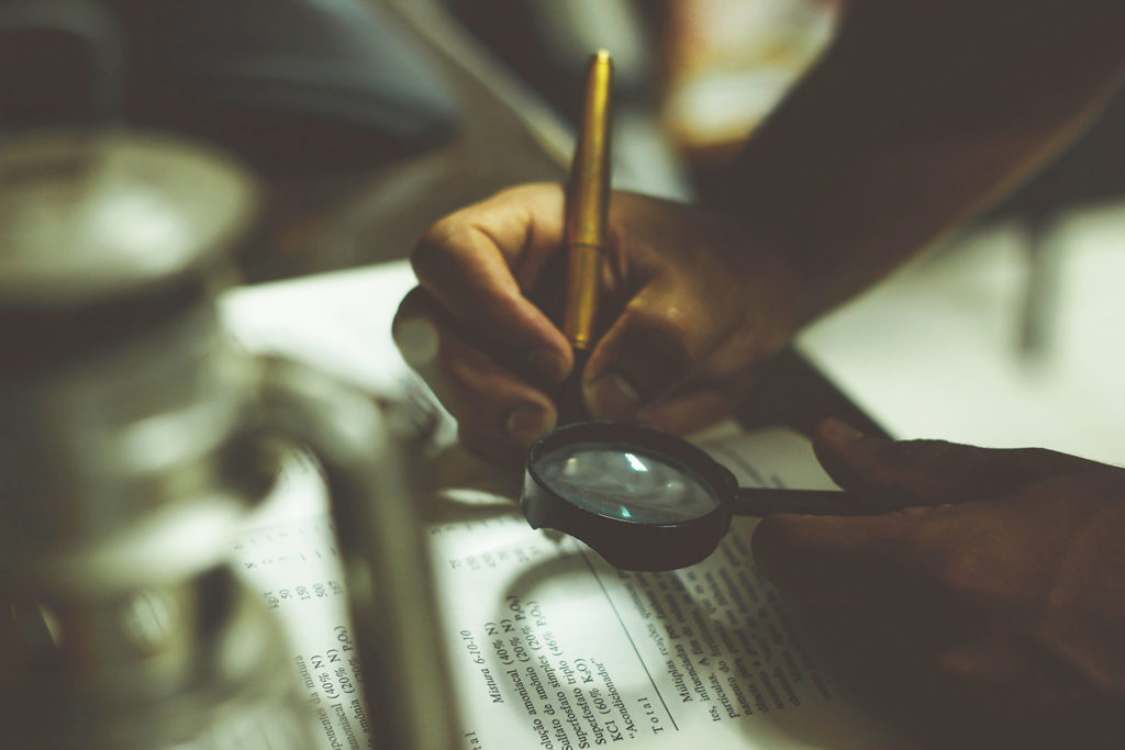 Person conducting research with a magnifying glass